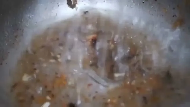 Sewer camera view of a pipe wall coated with brown debris and water