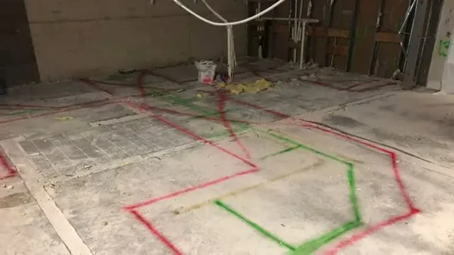 Concrete floor in an opened room marked with red and green lines