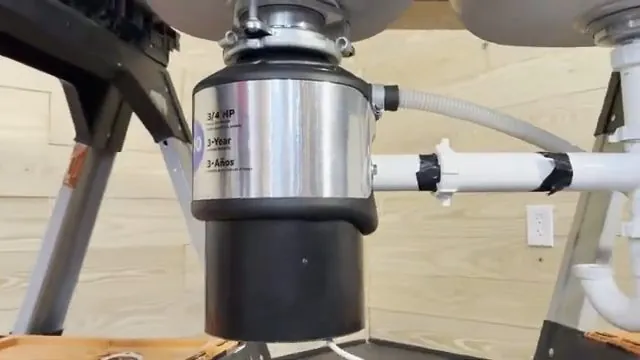 Garbage disposal mounted under a double sink with white drain pipes attached