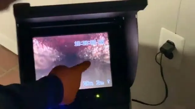 Hand pointing at the screen of a sewer inspection camera monitor