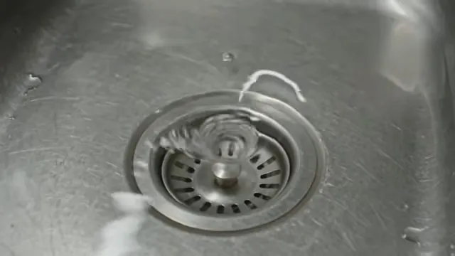 Stainless steel sink with water swirling around the drain strainer